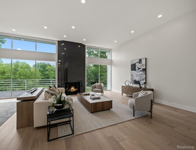 1756 Alexander Dr, Bloomfield Hills, MI 48302 - living area with a large fireplace, wood finished floors, recessed lighting, baseboards, and a high ceiling