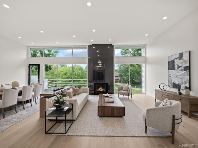 1756 Alexander Dr, Bloomfield Hills, MI 48302 - living room featuring light wood-type flooring, a large fireplace, a high ceiling, and recessed lighting