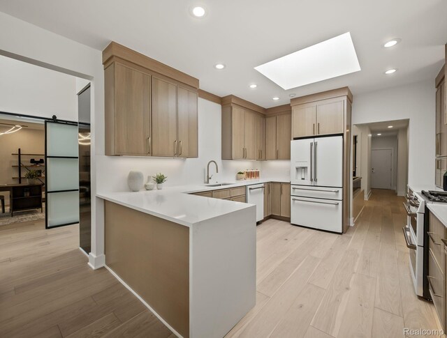 1756 Alexander Dr, Bloomfield Hills, MI 48302 - kitchen with white appliances, a sink, a skylight, a peninsula, and light wood finished floors