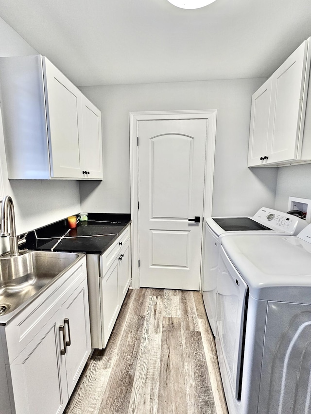 1982 S Benton Center Rd, Benton Harbor, MI 49022 - washroom with cabinet space, light wood finished floors, and washing machine and clothes dryer