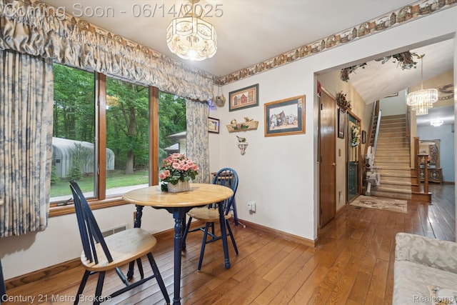 14210 W Burt Rd W, Chesaning, MI 48616 - dining area with a chandelier, wood-type flooring, and stairway
