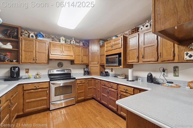 14210 W Burt Rd W, Chesaning, MI 48616 - kitchen featuring stainless steel appliances, light wood-style floors, light countertops, and brown cabinetry