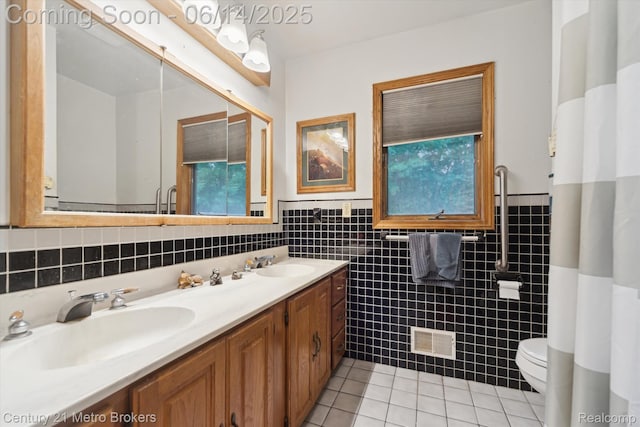 14210 W Burt Rd W, Chesaning, MI 48616 - bathroom with tile walls, tile patterned floors, double vanity, wainscoting, and plenty of natural light
