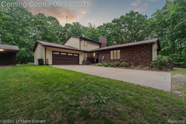 14210 W Burt Rd W, Chesaning, MI 48616 - view of front of property featuring an attached garage, a yard, a chimney, concrete driveway, and brick siding