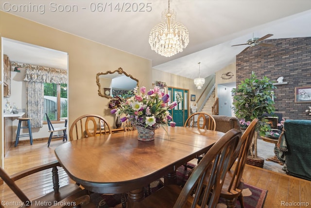 14210 W Burt Rd W, Chesaning, MI 48616 - dining area with hardwood / wood-style flooring, stairway, a chandelier, lofted ceiling, and brick wall