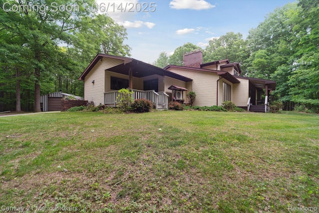 14210 W Burt Rd W, Chesaning, MI 48616 - rear view of property featuring a lawn, a chimney, covered porch, and an outbuilding