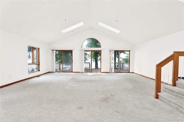 1870 Cass Lake Front Rd, Keego Harbor, MI 48320 - unfurnished living room featuring a skylight, high vaulted ceiling, stairs, carpet flooring, and baseboards