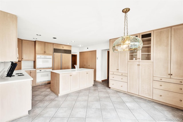 1870 Cass Lake Front Rd, Keego Harbor, MI 48320 - kitchen featuring double oven, paneled refrigerator, light countertops, light brown cabinetry, and a kitchen island with sink