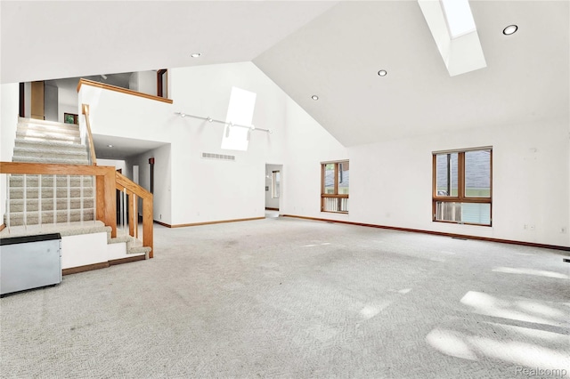 1870 Cass Lake Front Rd, Keego Harbor, MI 48320 - unfurnished living room with high vaulted ceiling, stairway, carpet floors, a skylight, and baseboards