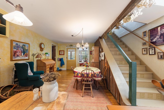 8425 Parshallville Rd, Fenton, MI 48430 - dining space featuring wallpapered walls, wood finished floors, a chandelier, and stairway