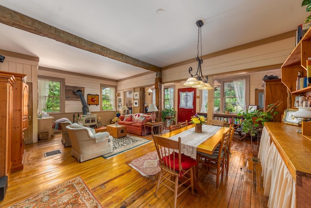 8425 Parshallville Rd, Fenton, MI 48430 - dining area with a wood stove, wood walls, hardwood / wood-style floors, and beamed ceiling