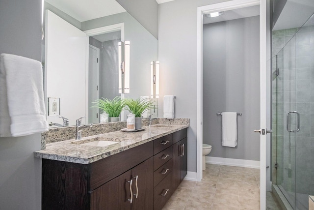 335 Bridge St NW Unit 500, Grand Rapids, MI 49504 - bathroom with double vanity, a stall shower, toilet, and baseboards
