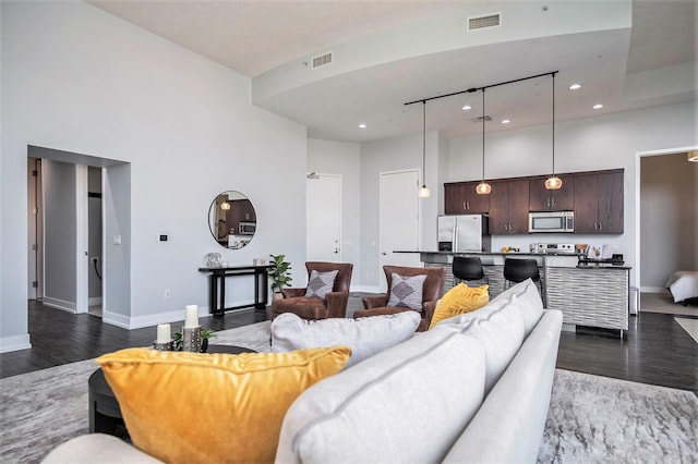 335 Bridge St NW Unit 500, Grand Rapids, MI 49504 - living room featuring a towering ceiling, dark wood finished floors, baseboards, and recessed lighting