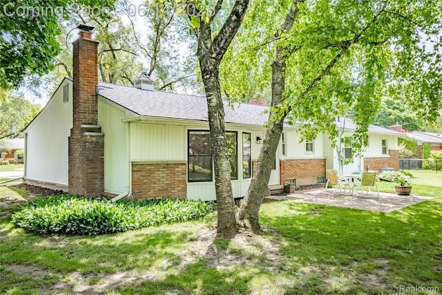 28441 Westerleigh Rd, Farmington, MI 48334 - back of property with brick siding, a chimney, a patio, and a shingled roof