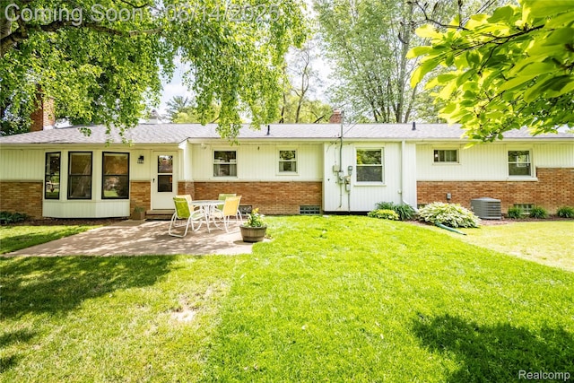 28441 Westerleigh Rd, Farmington, MI 48334 - back of property with brick siding, a chimney, a patio area, and a yard