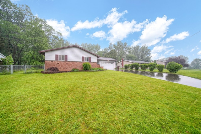 4109 Spring Arbor Rd, Jackson, MI 49201 - view of property exterior featuring brick siding, driveway, a garage, and a water view