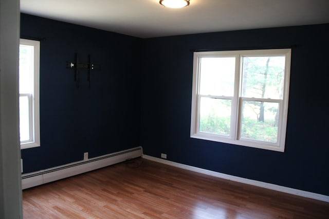 6994 E 34th Rd, Cadillac, MI 49601 - spare room with baseboard heating, light wood-type flooring, and baseboards
