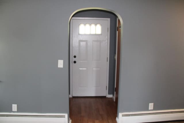 6994 E 34th Rd, Cadillac, MI 49601 - foyer featuring baseboard heating, arched walkways, a baseboard heating unit, wood finished floors, and baseboards