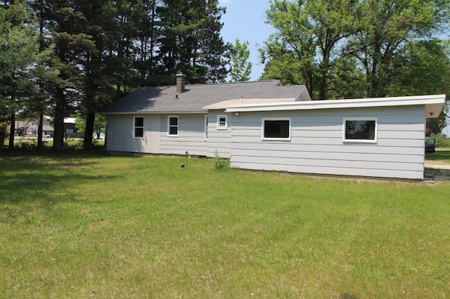 6994 E 34th Rd, Cadillac, MI 49601 - rear view of house with a lawn and a chimney