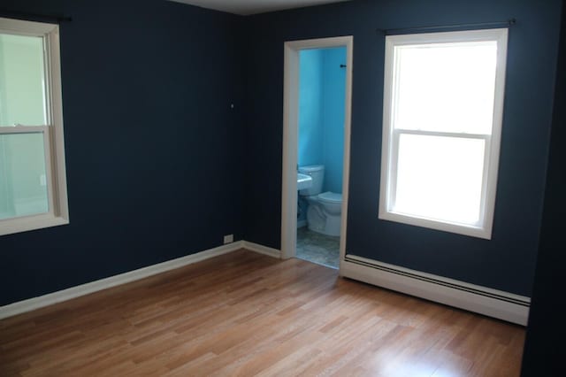 6994 E 34th Rd, Cadillac, MI 49601 - empty room with a baseboard radiator, light wood-type flooring, and baseboards