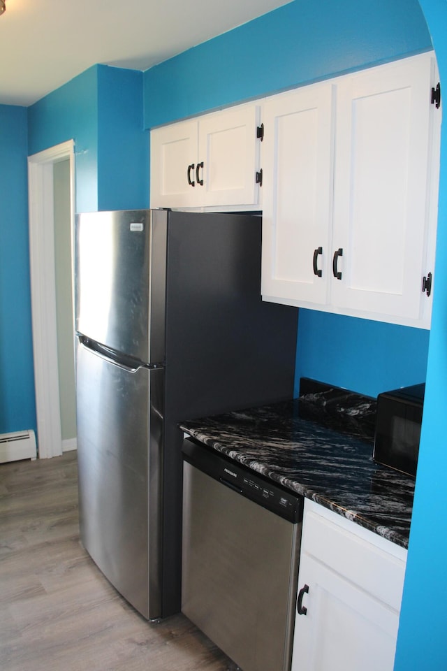 6994 E 34th Rd, Cadillac, MI 49601 - kitchen with appliances with stainless steel finishes, light wood-type flooring, white cabinets, and dark stone countertops