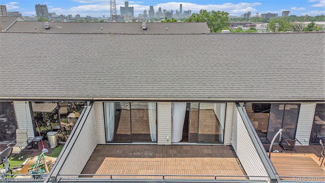 6533 E Jefferson Unit 427, Detroit, MI 48207 - rear view of property featuring a view of skyline and roof with shingles