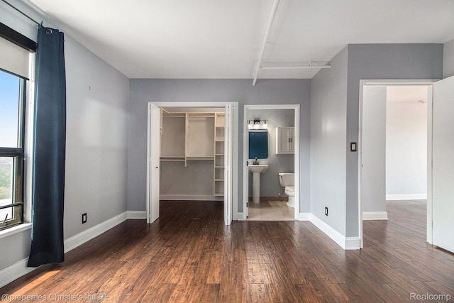 6533 E Jefferson Unit 427, Detroit, MI 48207 - unfurnished bedroom featuring wood finished floors, a walk in closet, a closet, and connected bathroom