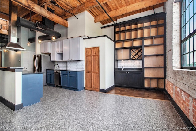 6533 E Jefferson Unit 427, Detroit, MI 48207 - kitchen with a wooden ceiling with exposed beams, dark countertops, decorative backsplash, appliances with stainless steel finishes, and a towering ceiling