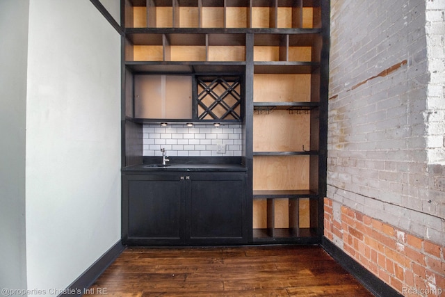 6533 E Jefferson Unit 427, Detroit, MI 48207 - indoor dry bar featuring dark wood-type flooring and decorative backsplash