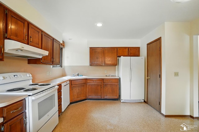 7658 Salter Ct, Temperance, MI 48182 - kitchen with white appliances, under cabinet range hood, light countertops, brown cabinets, and recessed lighting