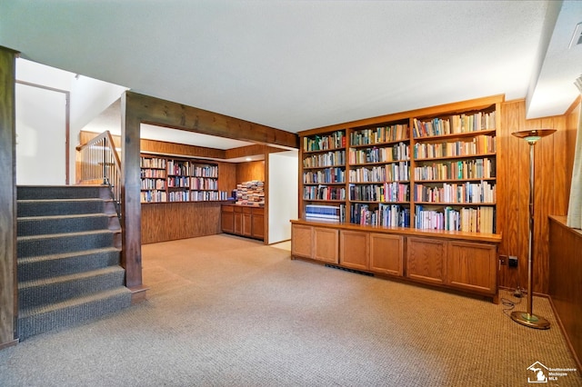 7658 Salter Ct, Temperance, MI 48182 - unfurnished room featuring wood walls, carpet floors, stairs, and wall of books