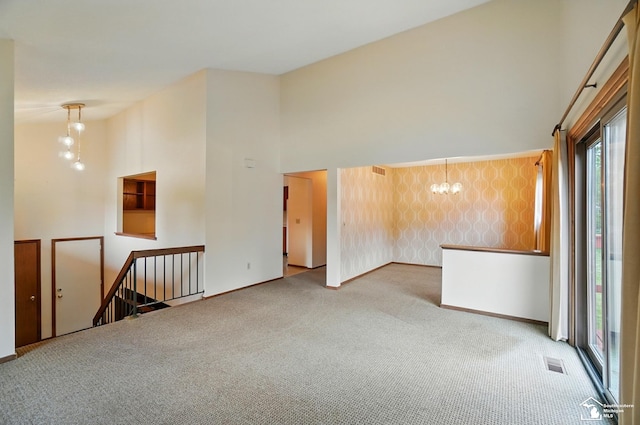 7658 Salter Ct, Temperance, MI 48182 - empty room with carpet flooring, a towering ceiling, and a chandelier