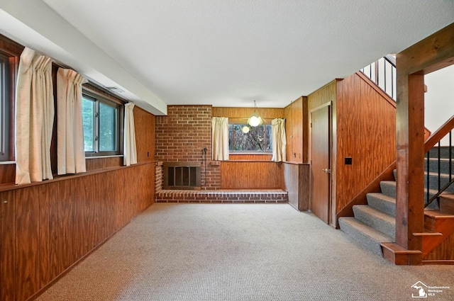 7658 Salter Ct, Temperance, MI 48182 - unfurnished living room with wood walls, carpet floors, stairs, and a brick fireplace
