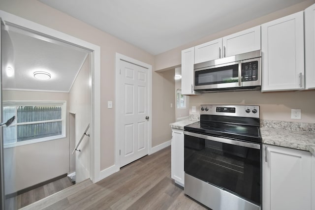 164 Cross St, Michigan Center, MI 49254 - kitchen with stainless steel appliances, white cabinets, light wood-style floors, baseboards, and light stone countertops