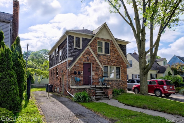 1722 W Farnum Ave, Royal Oak, MI 48067 - tudor home featuring brick siding, driveway, a front lawn, and a gate