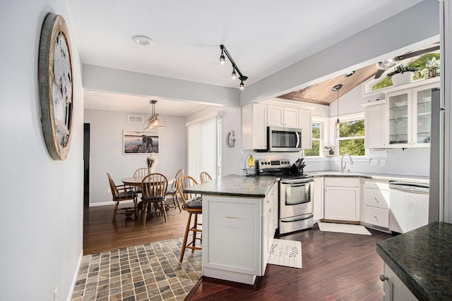 2030 Surry, Schoolcraft, MI 49087 - kitchen featuring appliances with stainless steel finishes, white cabinetry, dark wood-style floors, and lofted ceiling