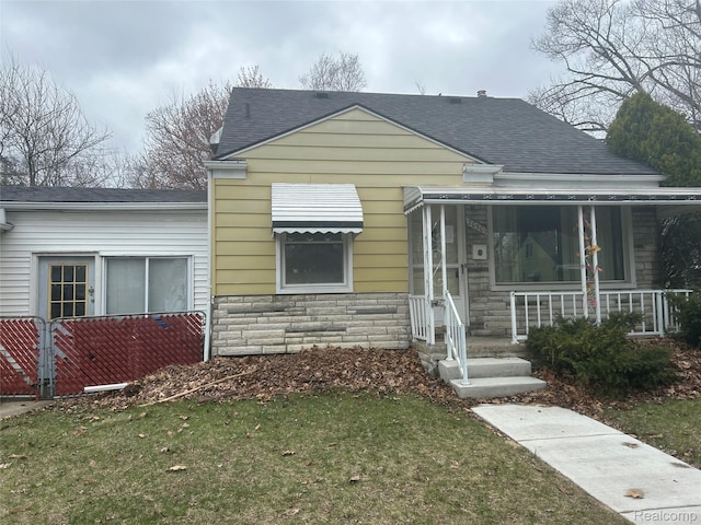 20501 Wakenden, Redford, MI 48240 - bungalow featuring stone siding, a shingled roof, covered porch, and a front lawn