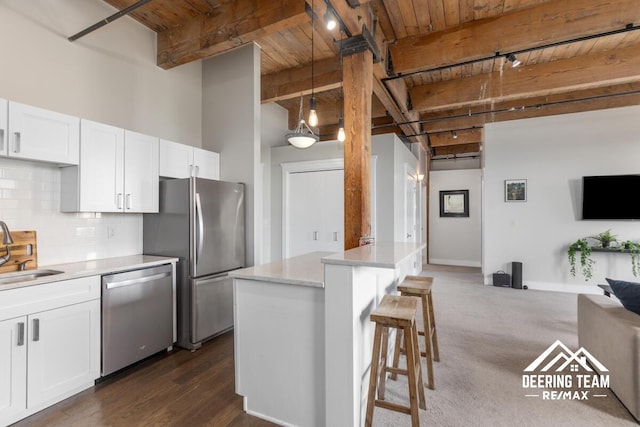940 Monroe Ave NW Unit 335, Grand Rapids, MI 49503 - kitchen featuring appliances with stainless steel finishes, wooden ceiling with exposed beams, rail lighting, tasteful backsplash, and white cabinetry