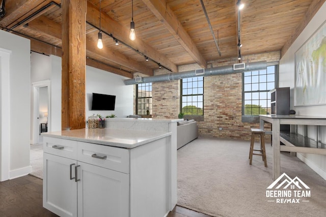 940 Monroe Ave NW Unit 335, Grand Rapids, MI 49503 - kitchen featuring brick wall, rail lighting, open floor plan, wooden ceiling with exposed beams, and white cabinets