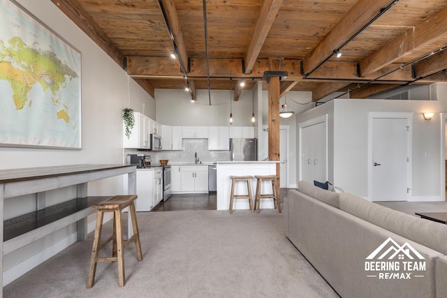 940 Monroe Ave NW Unit 335, Grand Rapids, MI 49503 - kitchen with appliances with stainless steel finishes, wood ceiling with exposed beams, carpet flooring, decorative backsplash, and open floor plan