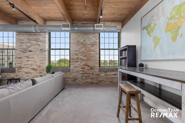 940 Monroe Ave NW Unit 335, Grand Rapids, MI 49503 - living room featuring a wood ceiling with exposed beams, brick wall, carpet flooring, plenty of natural light, and track lighting