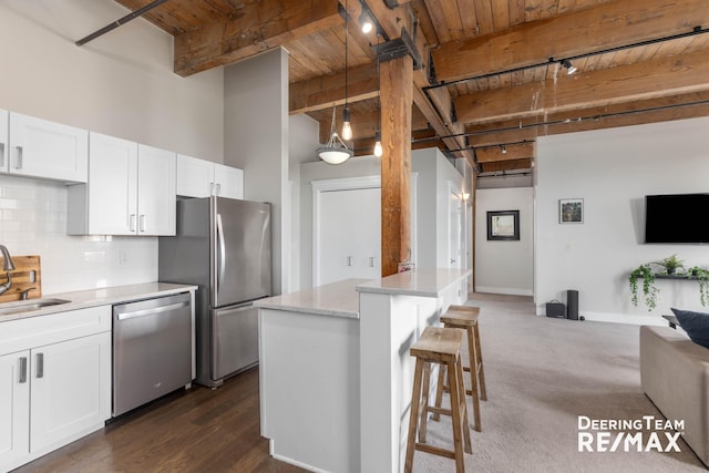 940 Monroe Ave NW Unit 335, Grand Rapids, MI 49503 - kitchen with appliances with stainless steel finishes, a wood ceiling with exposed beams, track lighting, white cabinetry, and decorative backsplash