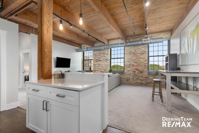 940 Monroe Ave NW Unit 335, Grand Rapids, MI 49503 - kitchen with rail lighting, brick wall, open floor plan, a wood ceiling with exposed beams, and white cabinets