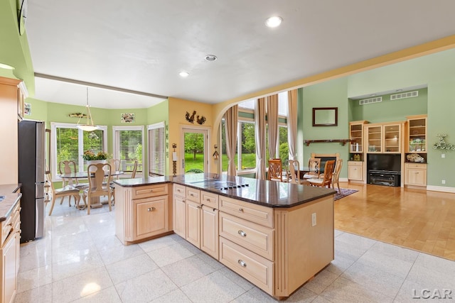 1269 Scott Ridge Dr, Adrian, MI 49221 - kitchen featuring freestanding refrigerator, light brown cabinets, recessed lighting, dark stone counters, and a kitchen island