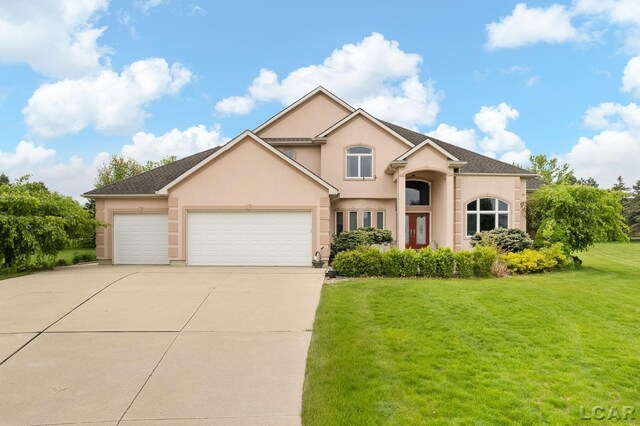 1269 Scott Ridge Dr, Adrian, MI 49221 - traditional-style home featuring stucco siding, driveway, an attached garage, and a front yard