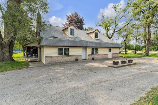2006 W Rose Center Rd, Holly, MI 48442 - view of front facade featuring brick siding and an outdoor fire pit