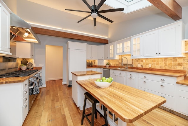 8562 W R Ave, Kalamazoo, MI 49009 - kitchen featuring butcher block countertops, range hood, ceiling fan, a sink, and backsplash