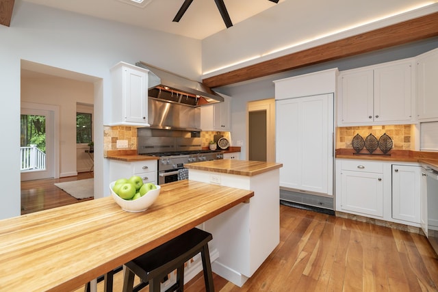 8562 W R Ave, Kalamazoo, MI 49009 - kitchen featuring butcher block counters, stainless steel gas range, white cabinets, backsplash, and island range hood