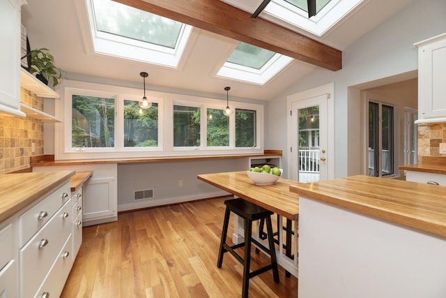 8562 W R Ave, Kalamazoo, MI 49009 - kitchen with wooden counters, a skylight, backsplash, and white cabinets