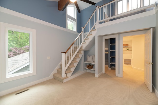 8562 W R Ave, Kalamazoo, MI 49009 - stairway featuring carpet, a ceiling fan, baseboards, a towering ceiling, and beamed ceiling